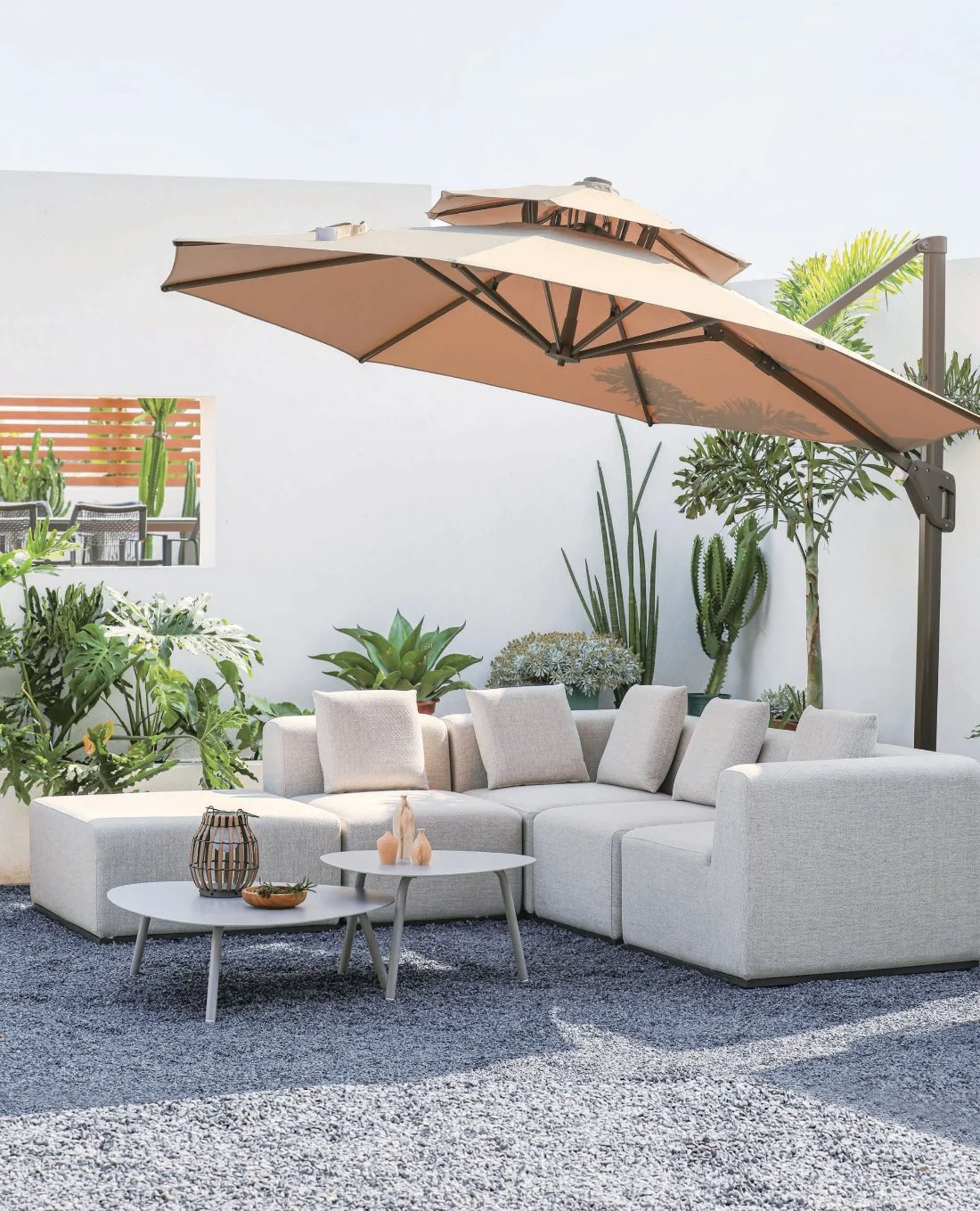 White modular outdoor sectional beneath a cantilever umbrella